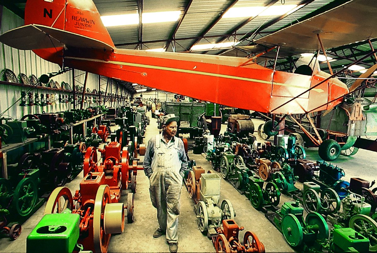 Oscar Cooke walks through his collection of gas, oil and steam engines at Oscar's Dreamland near Billings, Montana. Cooke, who owned over 300 vintage tractors, died in 1995 at the age of 94. A Rearwin Junior airplane hangs from the ceiling.