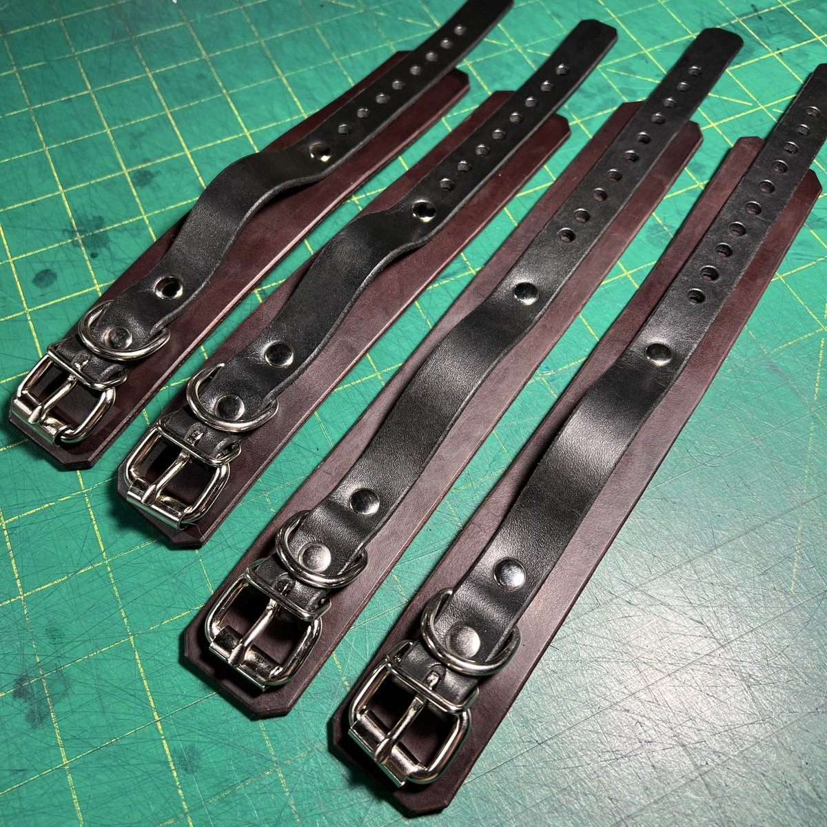 A set of heavy wrist (6"-8") and ankle (7"-10") cuffs made from stiff brown bridle leather and black latigo