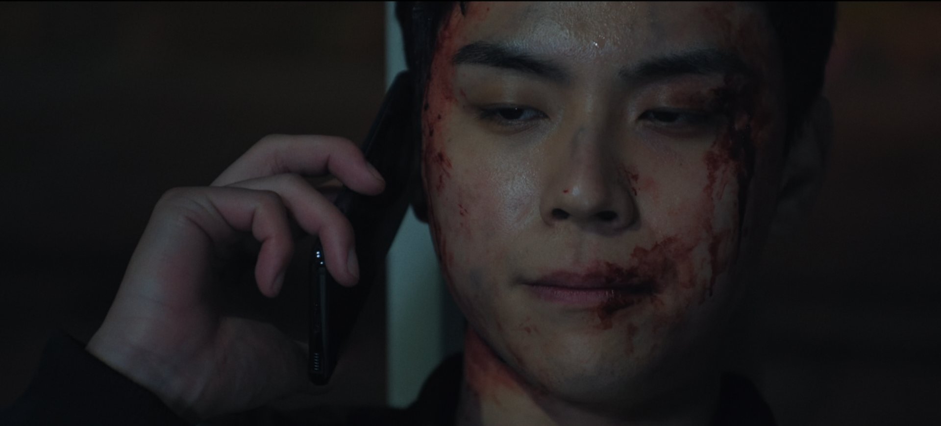 어두운 공간에서 통화를 하고 있는 재오의 스틸컷