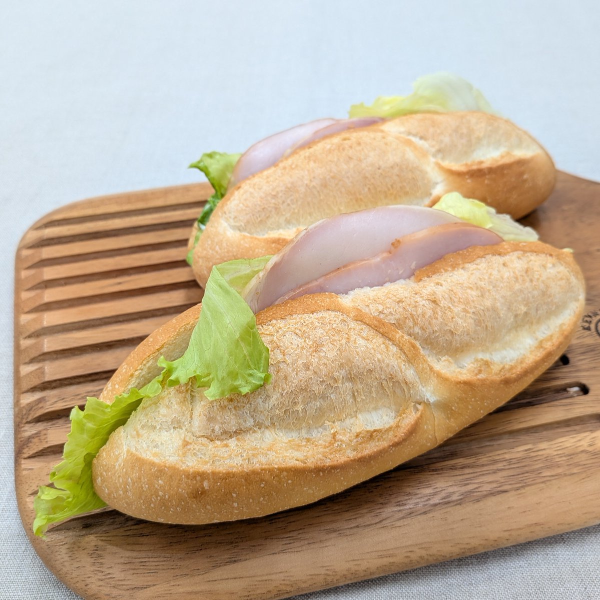 ハムッペ

外はパリッと、中はふんわりもっちりとした特製ソフトフランスパンにマスタードソースを塗り、ロースハムとレタスをサンドした総菜パン。マスタードのぴりりとした刺激がアクセントになっています。

wkobe.jp/bread/20251206/