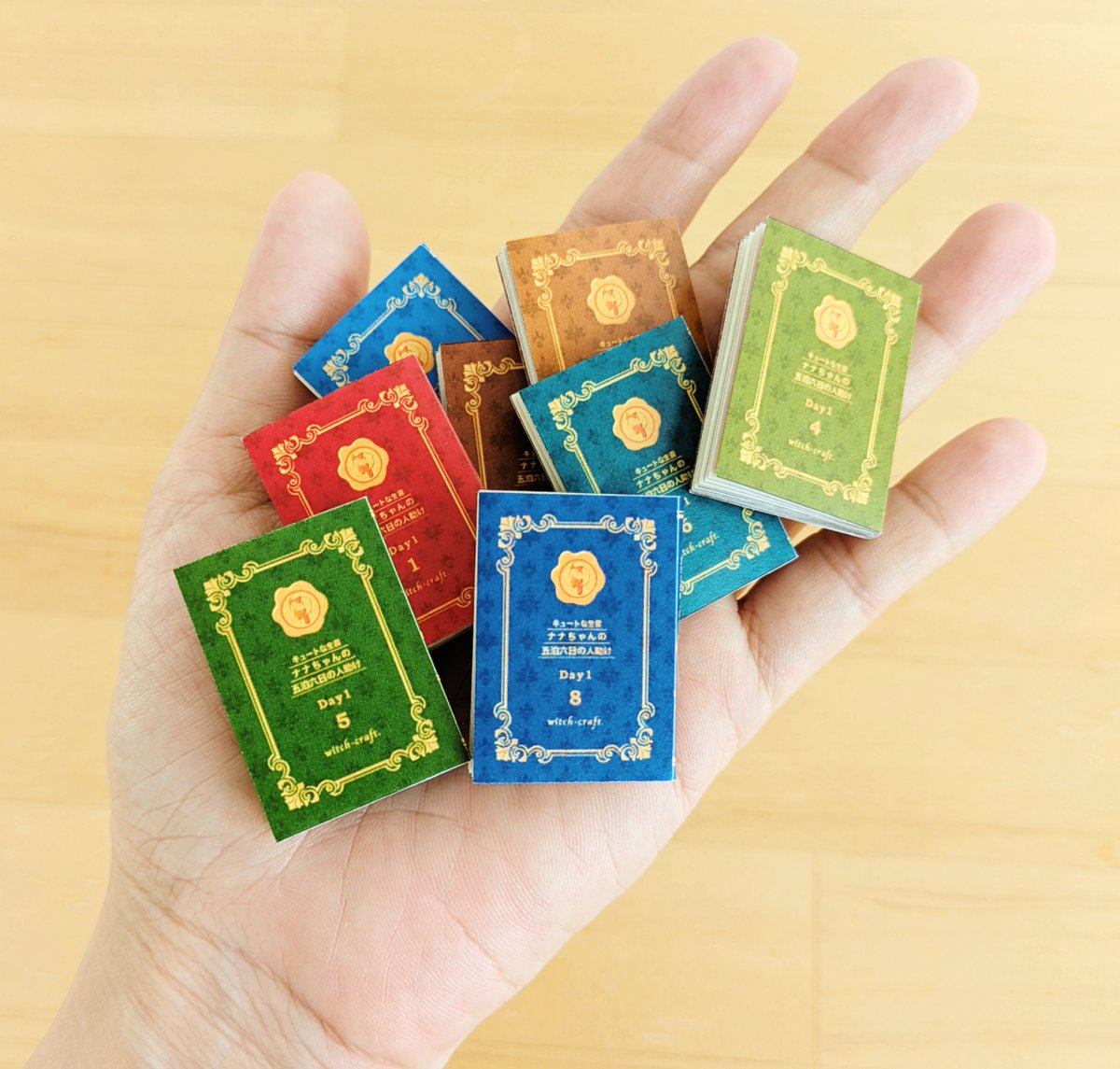 #ペーパーウェル15配信
『キュートな生首ナナちゃんの五泊六日の人助け』
50冊セットの豆折本を配布します。

並べた時に可愛いように、大きさやデザインを少しずつ変えました。
全７シートで、お好きなところだけプリントできます。
ドールさんやぬいさんの撮影小物にもぜひどうぞ。

プリント番号↓