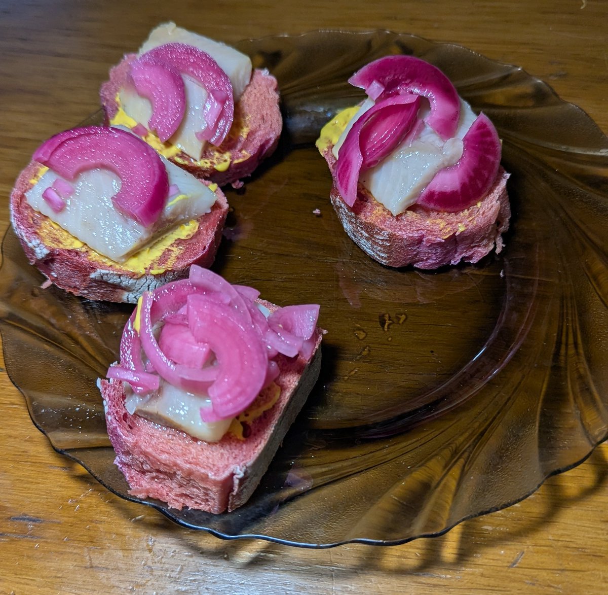 оселедець з рожевою цибулею на рожевому багеті