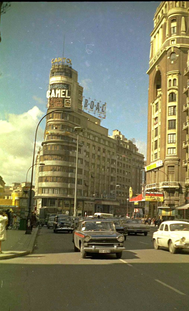 Animada Gran Vía con los edificios Capitol y Palacio de la Prensa en foto de 1964 ó 1965 ya que en el cine Palacio de la Prensa ponen "Por un puñado de dólares" de 1964, primera película de la trilogía de Sergio Leone sobre el oeste americano. Foto de J. Fernández en mi custodia