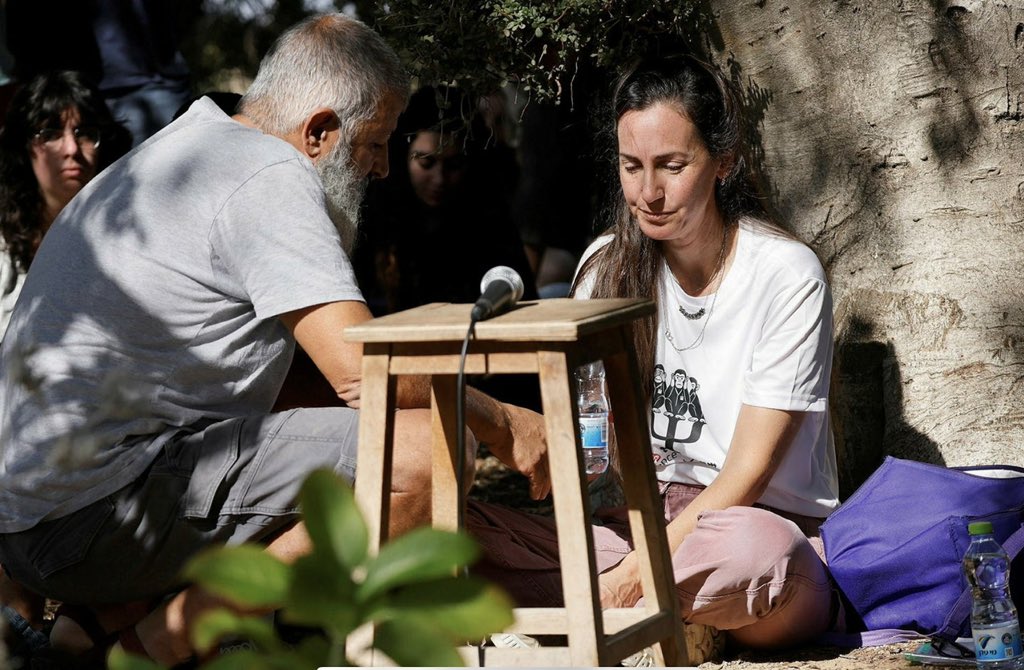 bar_peleg's tweet image. השמש בצבצה בין ענפי העצים בבית העלמין בניר בנים. על כיסא בר ישב רון קהתי, על האדמה לידו ישבו אשתו מעיין וילדיהם. סמוך להם קברו של בנם שנפל, גור.  &quot;כל כולי צער מכף רגל עד האינסוף״ אמרה מעיין כשהיא ישובה על האדמה. ״אני מצטערת שלא שמרתי עליך מהנרטיב האכזרי של הארץ הזו. הפרחת את…