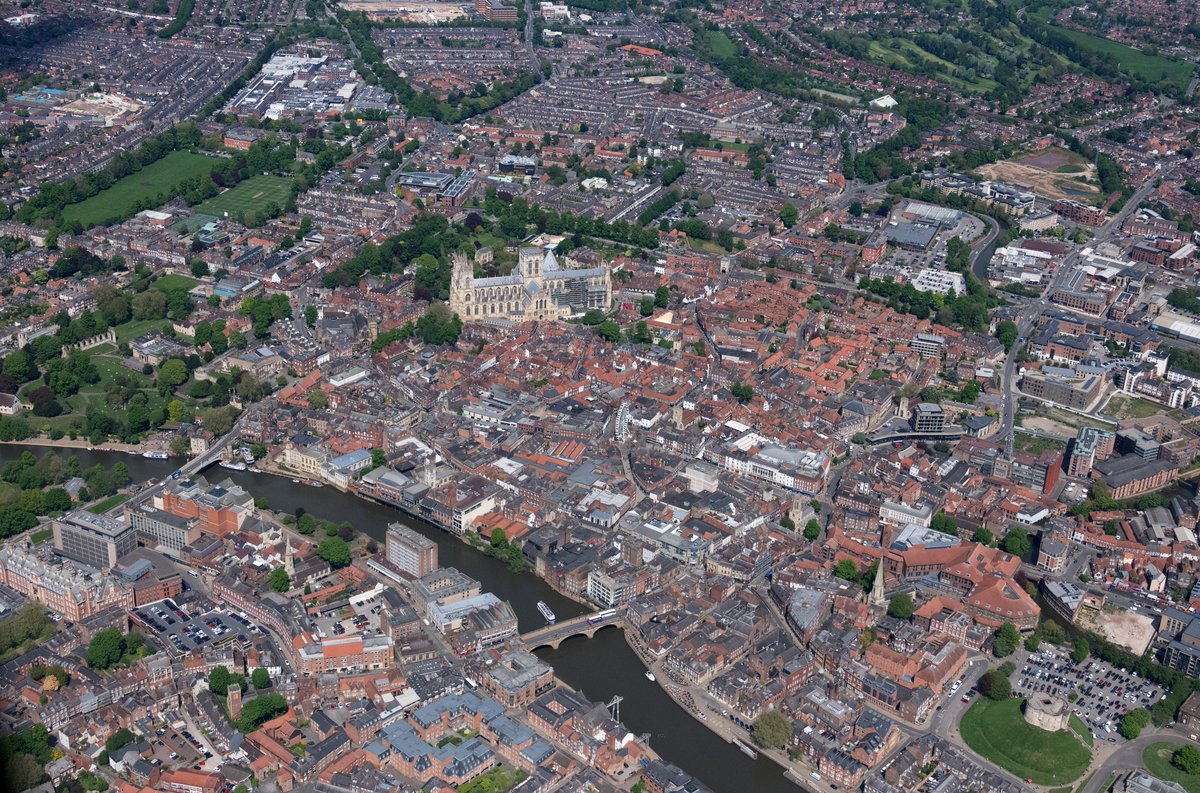 johnfielding001's tweet image. A clear day over York – the River Ouse winding through centuries of streets and rooftops, with the great Minster dominating the city centre. Medieval street patterns still visible from above alongside modern developments #York #aerial #image #Yorkshire