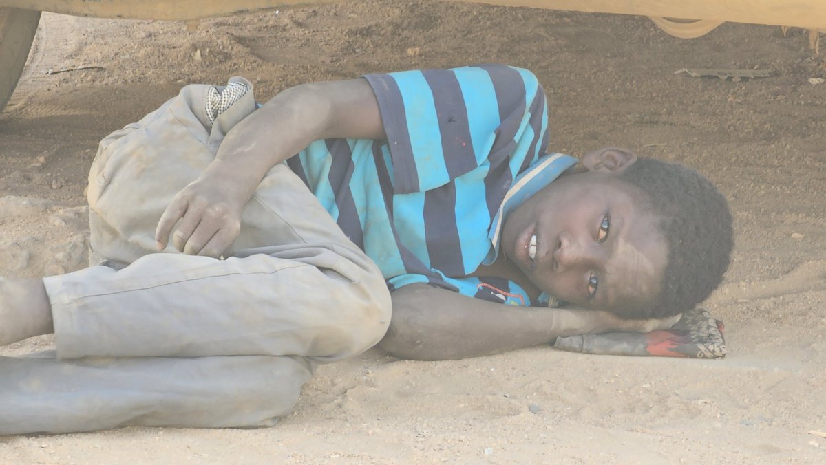 Beneath the shadow of a car in Khartoum,
a boy lay on the ground,
seeking the only shelter he could find.

He didn’t speak.
He didn’t need to.
His tears carried the weight of a war
he never chose,
a childhood interrupted
by the noise of men, guns, hunger, and fear.
#Sudan