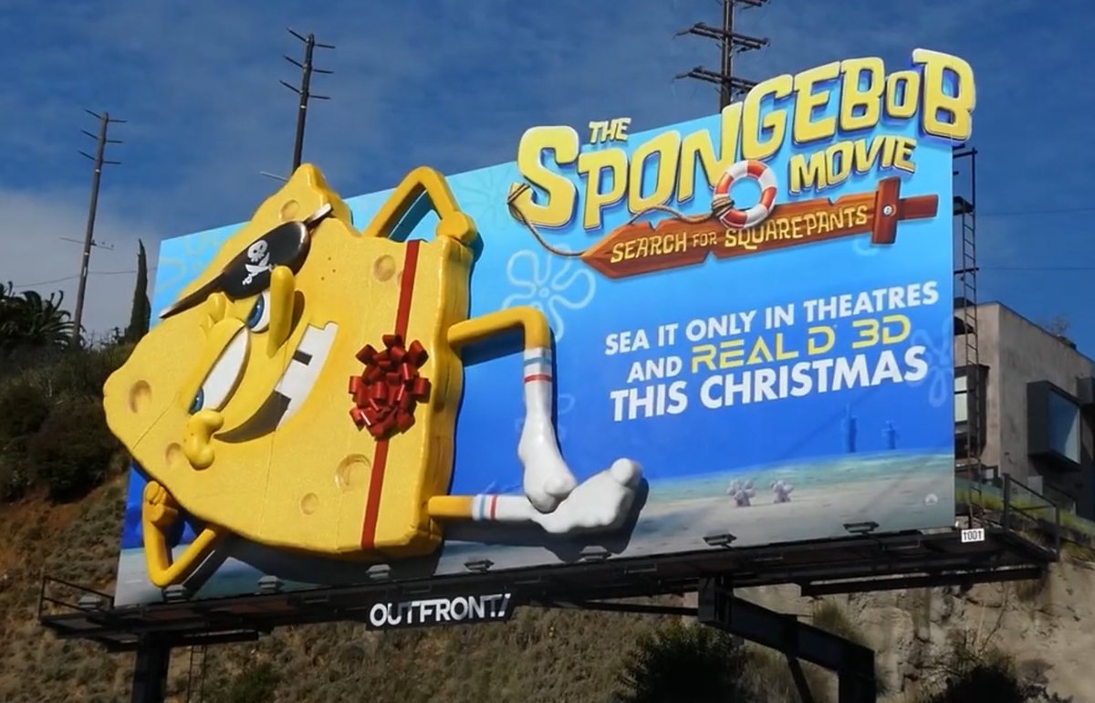 ToonHive's tweet image. SpongeBob poses wearing just a bow on a billboard to promote his new movie ‘The SpongeBob Movie: Search for SquarePants’.