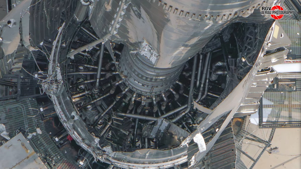 SUPER HEAVY V3, SÓ QUE POR DENTRO!
Nesta imagem incrível do <a href="/RGVaerialphotos/">RGV Aerial Photography</a> podemos ver o interior do Booster 18, que ficou exposto após uma falha durante um teste de pressurização. 
Toda a tubulação que abastece os 33 Raptors e a extensão dos danos é visível, além disso, é