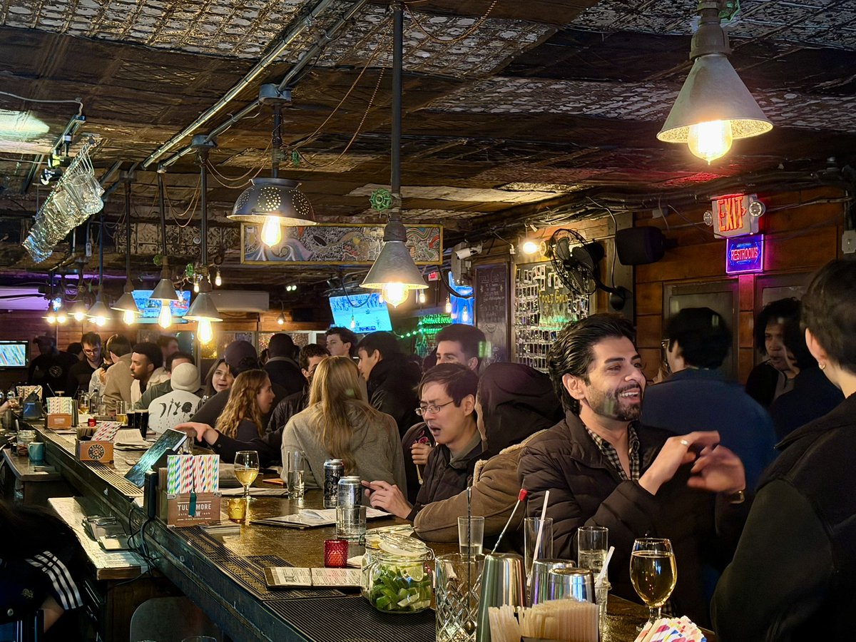 Crowded bar with people chatting and drinking during the Kalshi x Solana happy hour event