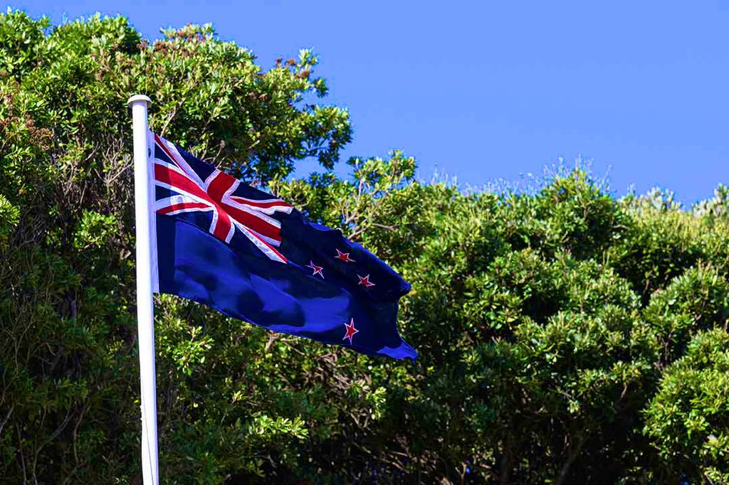 New Zealand flag waving against a blue sky