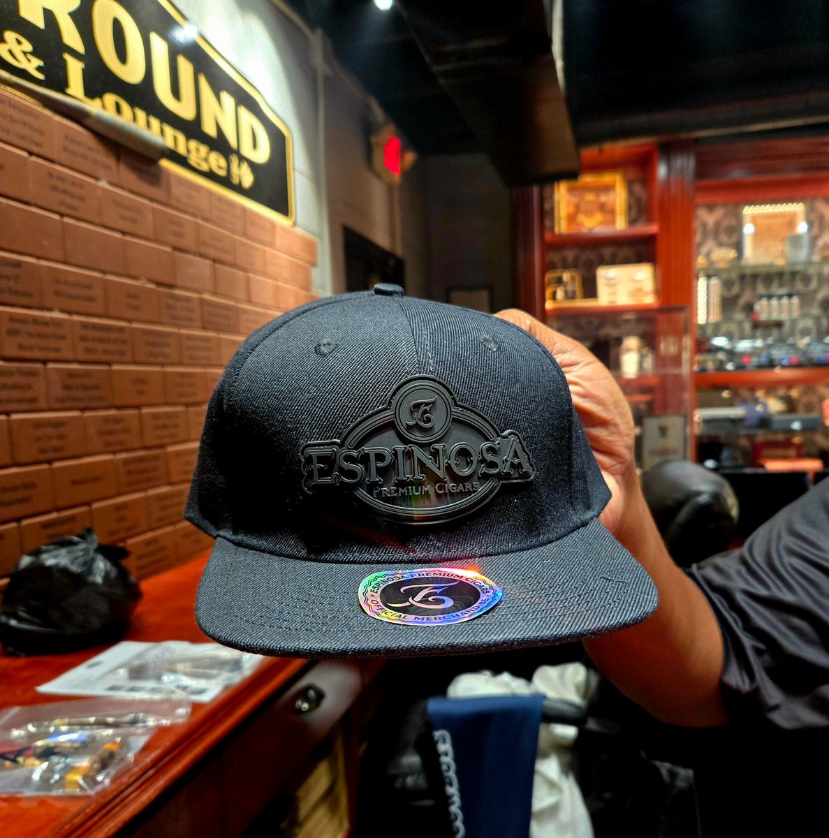 Kelton Carpenter won this hat and is donating it back to the person who buys the most Espinosa samplers. 

What is this black on black Espinosa hat called? The verbiage.