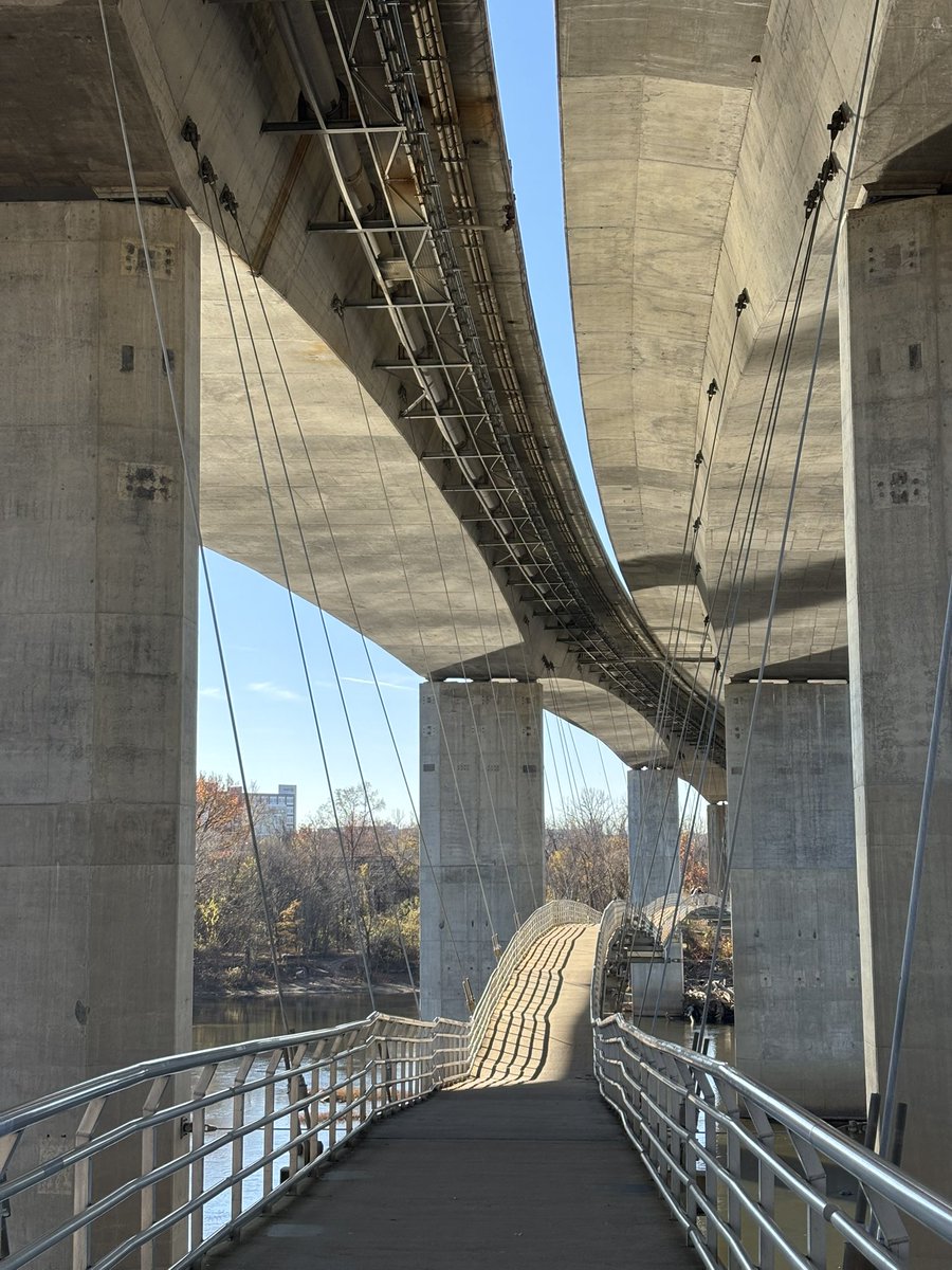 昨天拍到很喜歡的照片，在橫跨河面的高架橋下，有一條專門給行人走的橋，抬頭正好出現凝結尾