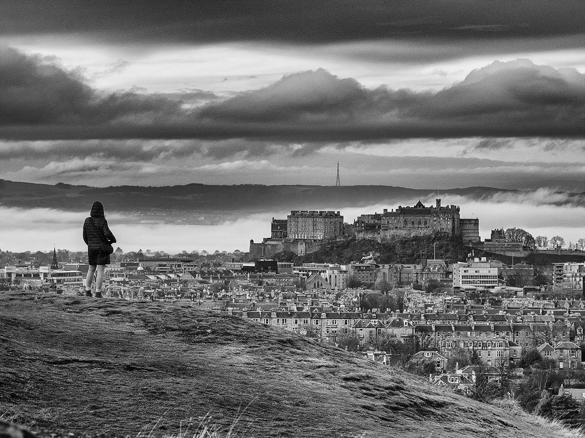 My wife will sometimes reluctantly pose in a shot for me and I didn't want to wasted the opportunity of a unique view of the city with some cloud building along the Forth estuary behind it.

<a href="/edinburghcastle/">Edinburgh Castle</a> #Edinburgh