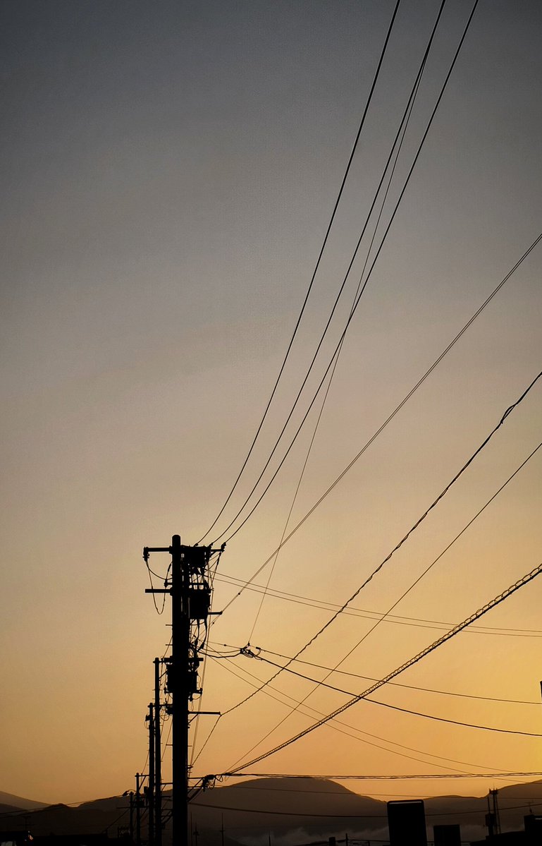 The quiet drama of a street sunrise. Power lines tracing the