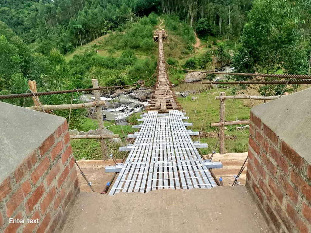 MoWT_Uganda's tweet photo. The Division of Drainage Structures, in partnership with Bridges to Prosperity (B2P), is currently undertaking a hands-on training in the maintenance of the Kama Trail Bridge in Sironko.

This exercise focuses on replacing the original timber decking with durable galvanized steel — a major step toward safer, longer-lasting connectivity for the community.

Kama Trail Bridge was B2P’s first demonstration bridge, built with a timber deck, but rapid deterioration of the planks soon posed a safety risk.

To ensure sustainable maintenance across all trail bridges built across hard to reach mountainous parts of the country, the Ministry is empowering District Engineering teams through practical, on-site training to ensure sufficient local capacity to build and maintain trail bridge assets thereby prolonging their lifespan.

#InclusiveGrowth
@B2P