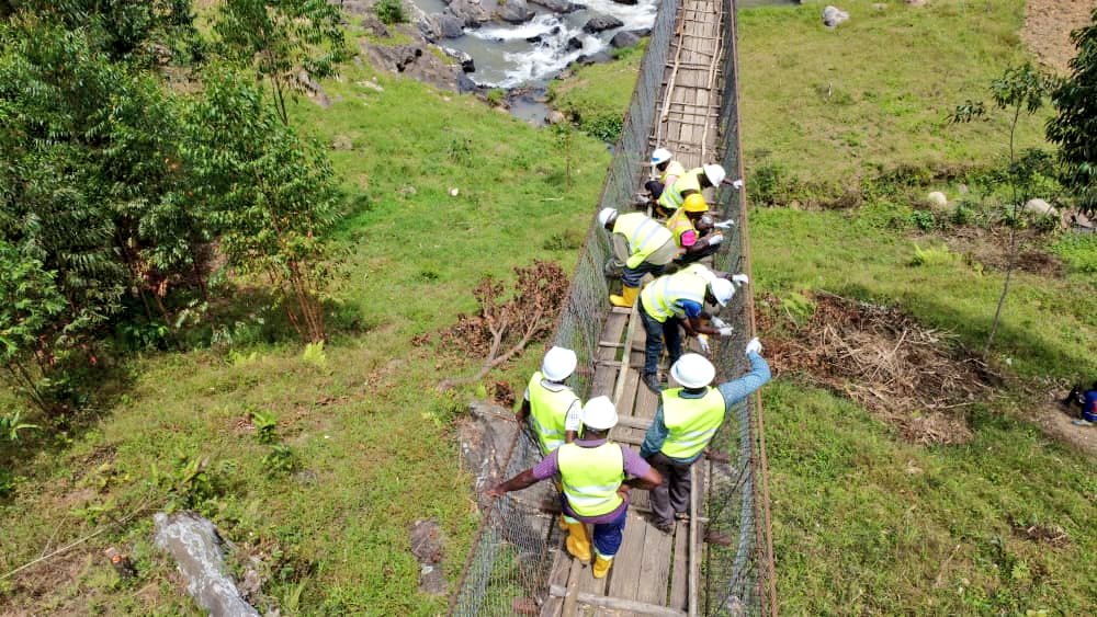 MoWT_Uganda's tweet photo. The Division of Drainage Structures, in partnership with Bridges to Prosperity (B2P), is currently undertaking a hands-on training in the maintenance of the Kama Trail Bridge in Sironko.

This exercise focuses on replacing the original timber decking with durable galvanized steel — a major step toward safer, longer-lasting connectivity for the community.

Kama Trail Bridge was B2P’s first demonstration bridge, built with a timber deck, but rapid deterioration of the planks soon posed a safety risk.

To ensure sustainable maintenance across all trail bridges built across hard to reach mountainous parts of the country, the Ministry is empowering District Engineering teams through practical, on-site training to ensure sufficient local capacity to build and maintain trail bridge assets thereby prolonging their lifespan.

#InclusiveGrowth
@B2P
