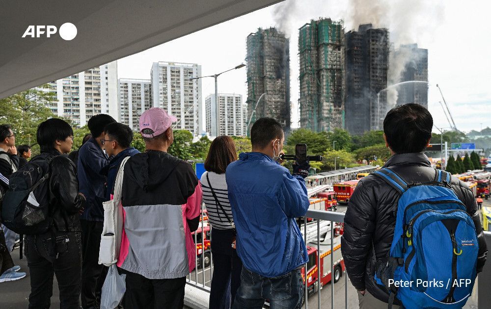 AFP's tweet photo. #UPDATE  At least 55 dead, over 250 missing after Hong Kong's deadliest blaze in decades.

Over 24 hours after fire broke out in the eight-building housing estate with 2,000 units, flames were still visible in some windows 

https://t.co/1AQmqnZAs6 https://t.co/gBAsG03Q6t