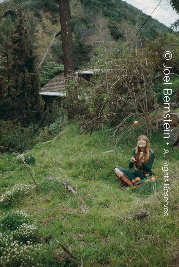 joniarchive's tweet photo. joni mitchell tossing an orange behind her famous house in laurel canyon, taken during a photoshoot for her album blue in 1971, photo by joel bernstein https://t.co/LMXb9mx7Zc