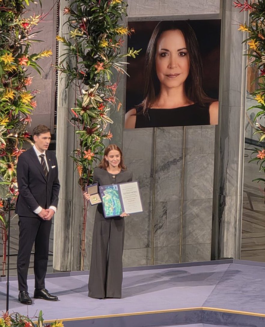 Mayer's tweet photo. Su propia ausencia recalca lo atinado que fue otorgarle el premio nobel a @MariaCorinaYA y la lucha del pueblo de Venezuela 🇻🇪 Y que mayor transmisor de esa lucha que las palabras de MC emitidas por su propia hija Ana Corina con apenas 34 años. Dios bendiga al pueblo venezolano https://t.co/ZrdnNuaod0