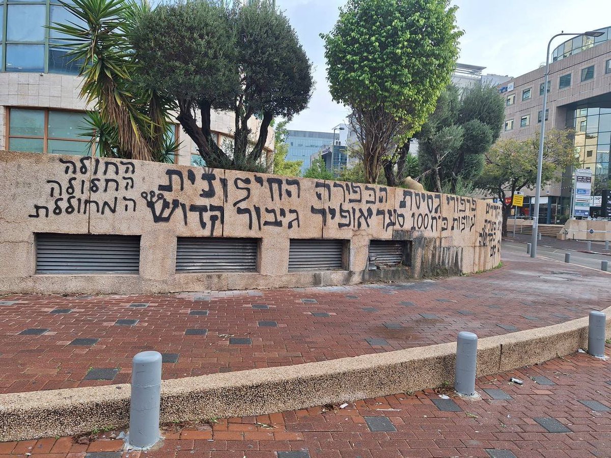 Slonim's tweet image. בשולי: בניין רשת 13 נמצא מול בית חולים גדול. יש שם תנועה לאורך כל הלילה. אני יודע כי עשיתי שם MRI השבוע בשלוש לפנות בוקר. איך אפשר להפוך שם קיר שלם לגראפיטי כזה בלי שאף אחד ישים לב?