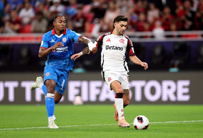 Giorgian de Arrascaeta of CR Flamengo is challenged by Willer Ditta of Cruz Azul during the FIFA Derby of the Americas 2025 match between Cruz Azul and CR Flamengo at Ahmad Bin Ali Stadium.