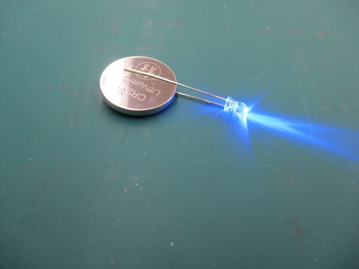 砲弾型LEDの定格電圧は、白、青がだいたい3.2V。赤、黄が1.8～2Vが多いです。3.2Vクラスはボタン電池（3V)で点灯しますが、2Vクラスは乾電池（1.5V)では点灯しません。エレキットさんのE10ソケット用の電球は定格1.5Vなので点灯します。赤、青、白、電球色と在庫してます。
よろしくお願いいたします。