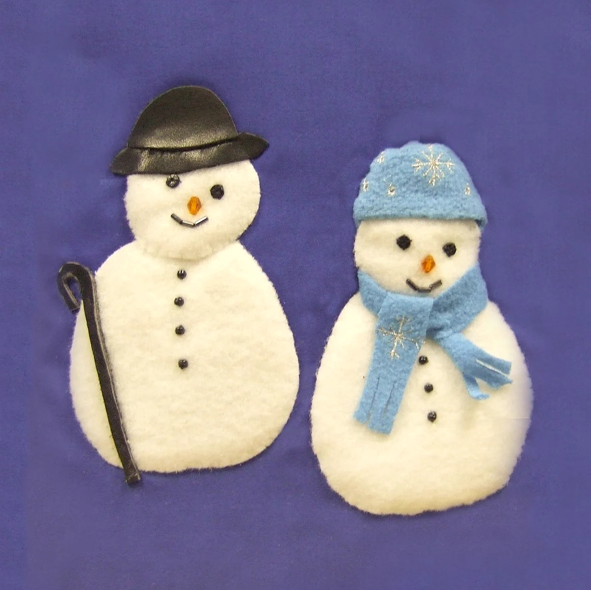 A image from a ClearVision tactile picture book showing two snowman, one with a black hat and walking stick and the other with a pale blue hat and scarf.