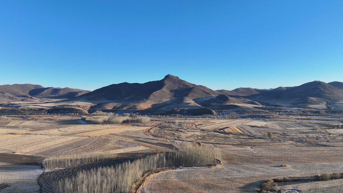 In Horqin Right Wing Front Banner, Hinggan League, Inner Mongolia, Heiniu Mountain is clad in a light dusting of snow.  The winding river bends in a golden glow.  The forest and fields are shrouded in the cold of winter, but the wilderness is unspoiled and peaceful.