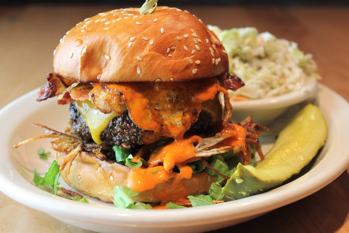 Craving a hearty meal? 😋 Dive into our Hangover Burger at The Barley House Restaurant &amp; Tavern! 🍔 A peppercorn charred burger topped with potato cake, bacon, cheddar, fried egg, buffalo sauce, lettuce &amp; tomato. #BurgerLove #BarleyHouseEats 🍴