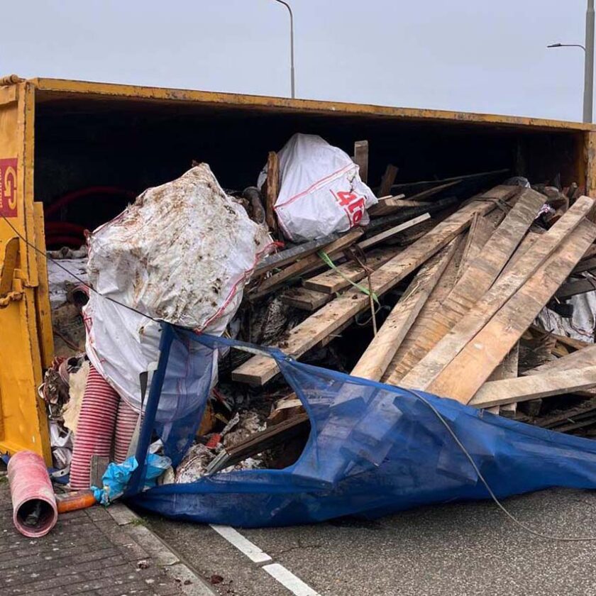 Afvalvrachtwagen kantelt op rotonde in Vijfhuizen