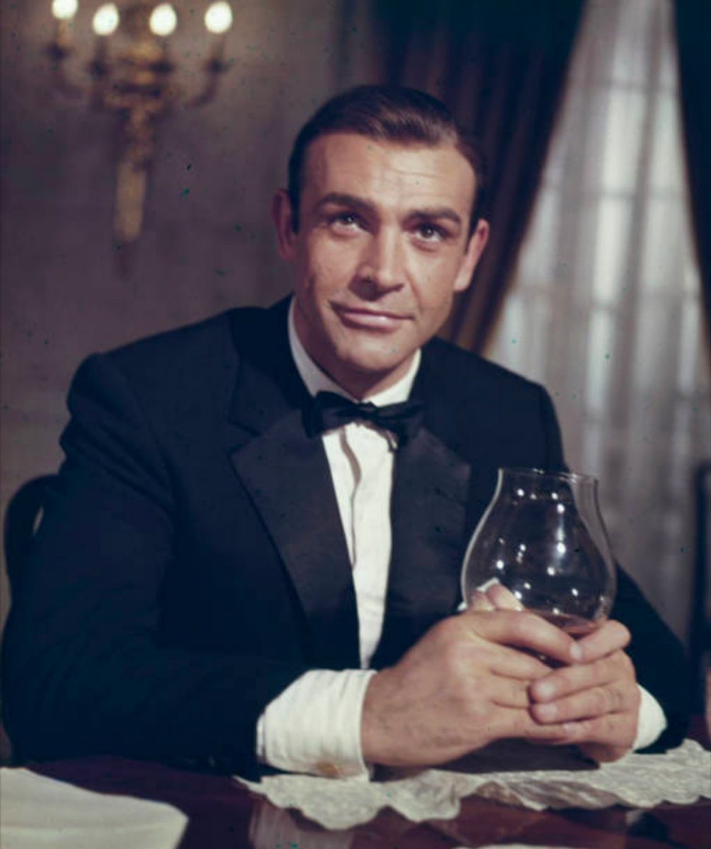 kunalerror's tweet image. Sean Connery wearing tuxedo holding brandy glass as James Bond 007 from 'Goldfinger' 1964.