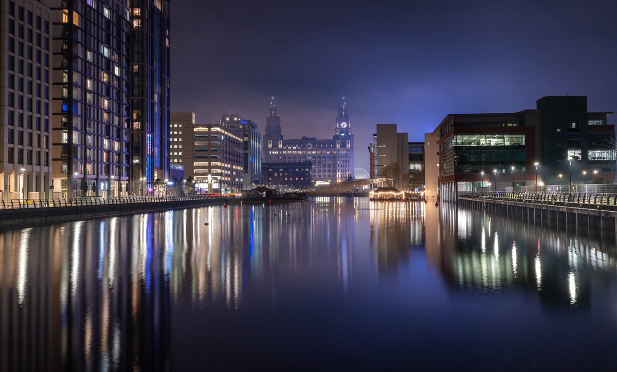 Geoff_Drake's tweet image. ‘Indigo Skies’ -After taking the drone photograph at the Pier Head last Saturday, I took a walk around Prince’s Dock. The little bit of mist in the air was reflecting the bright lights from the fairground rides and creating this beautiful glow across the Pier Head and dock..