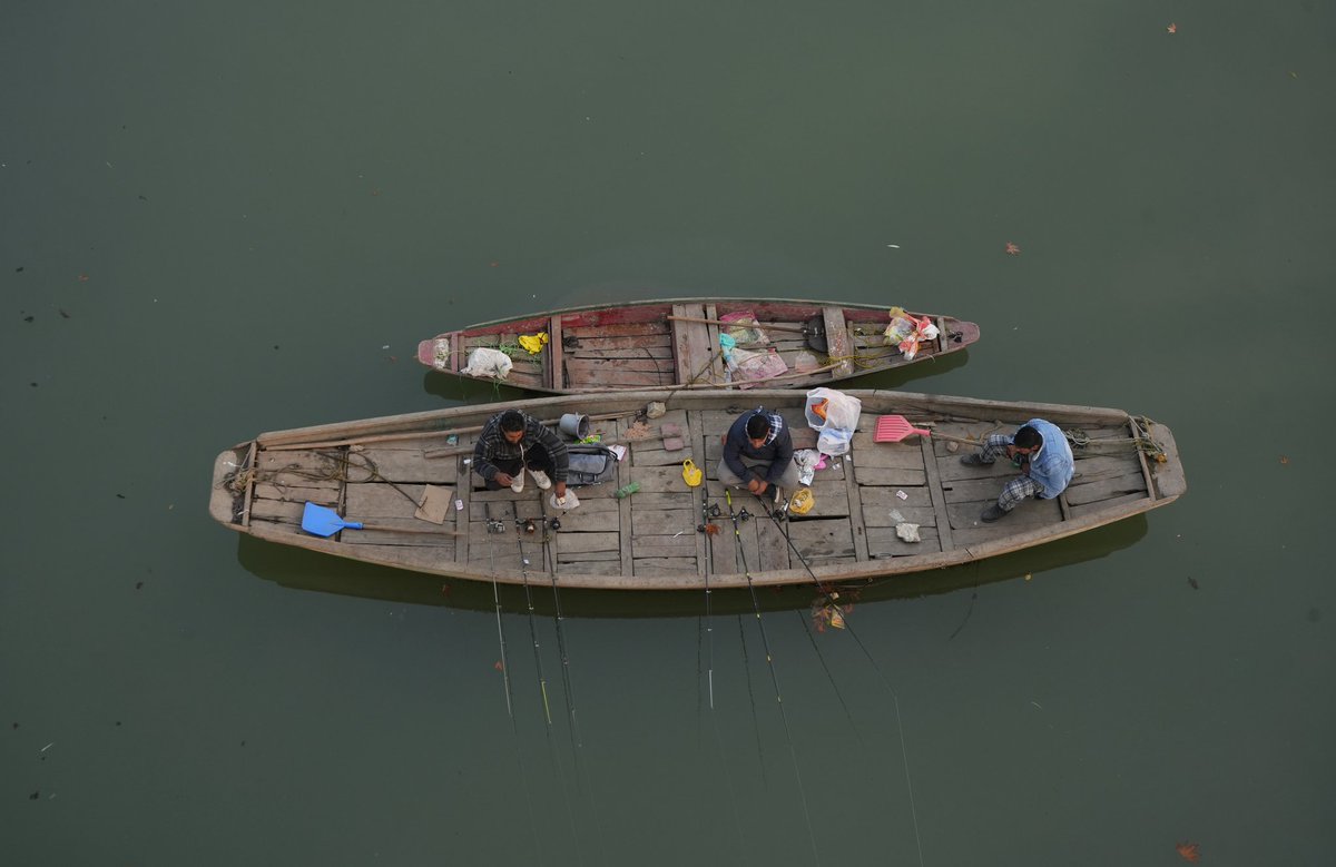Men fish while sitting in a boat on the waters of the Jhelum River in Srinagar.

Photo: <a href="/Sameerhussain95/">Sameer Hussain</a>