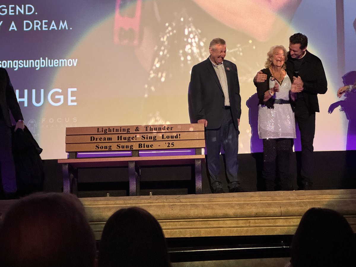tmj4's tweet photo. During the premiere of 'Song Sung Blue,' actor Hugh Jackman presented Claire Sardina with a bench that will be placed at the Wisconsin State Fair Park. https://t.co/8POVtTJlJ3