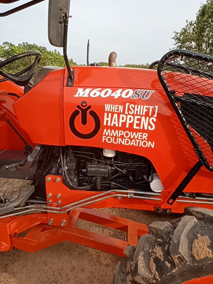 캄보디아 농촌에 놓인 MMPower Foundation 로고가 붙은 트랙터 클로즈업