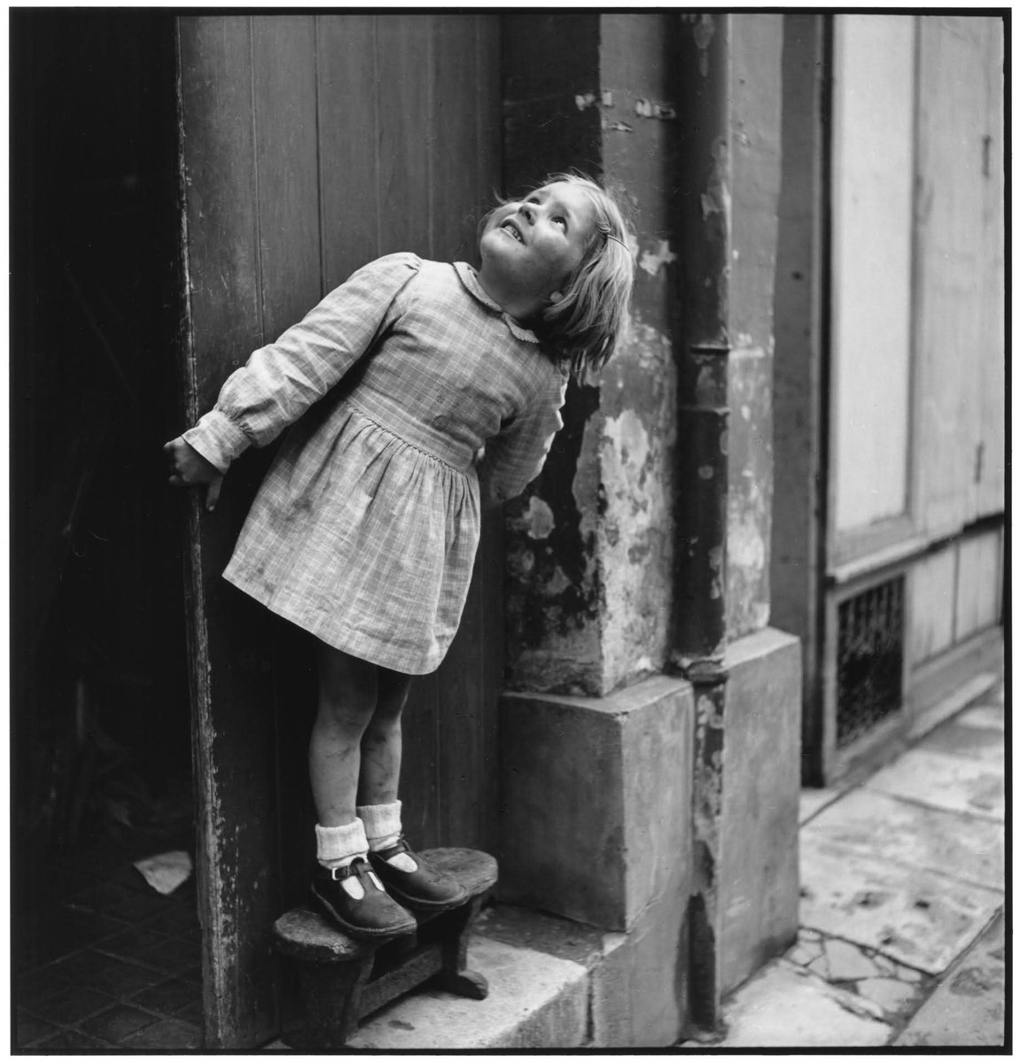 📸 Elliott Erwitt. 
La fillette qui regarde au-dessus 
1949. Paris