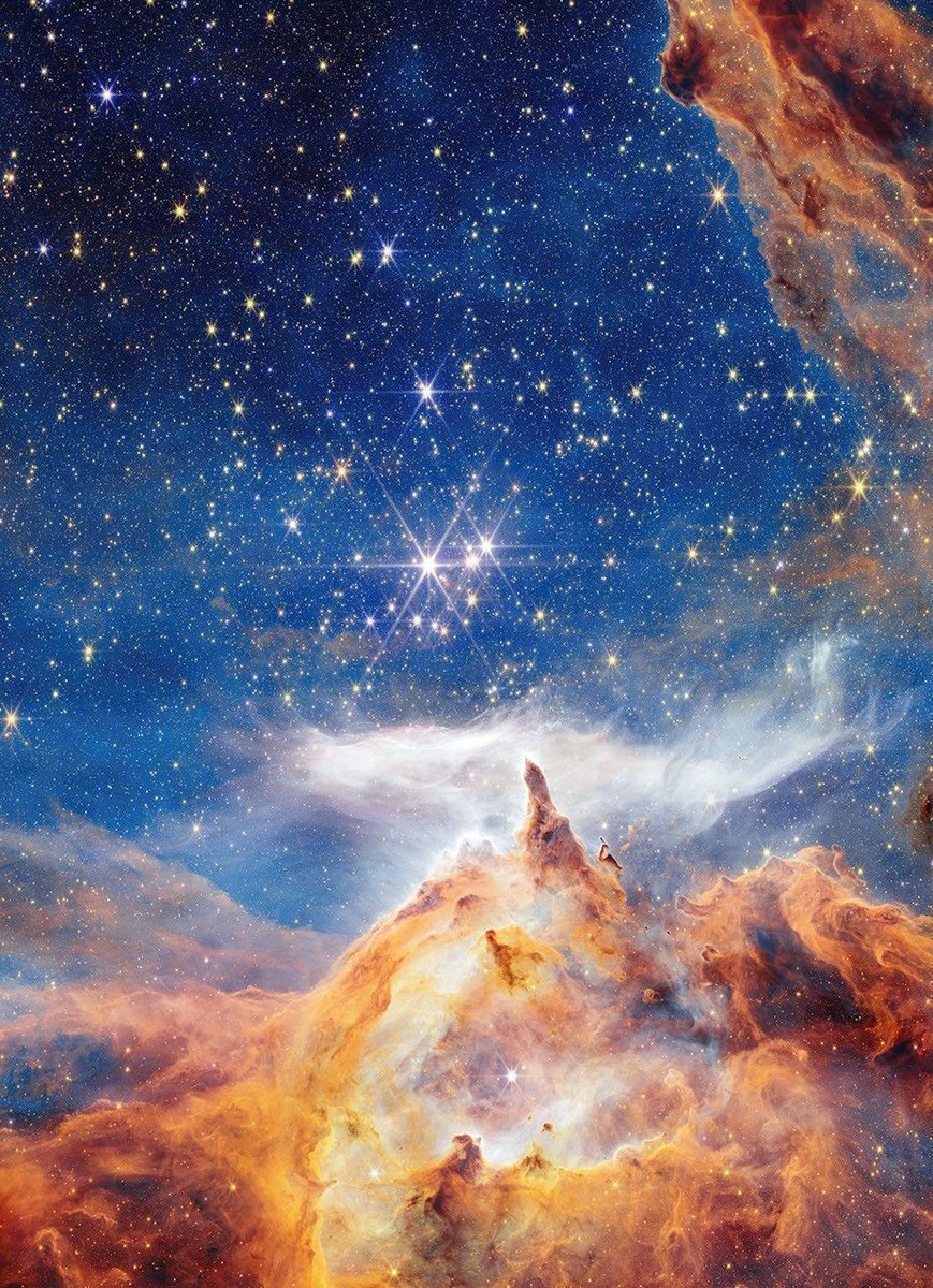 #PPOD: Glittering Glimpse of Star Birth ✨ 

This is a sparkling scene of star birth captured by <a href="/NASAWebb/">NASA Webb Telescope</a>. What appears to be a craggy, starlit mountaintop kissed by wispy clouds is actually a cosmic dust-scape being eaten away by the blistering winds and radiation of nearby,