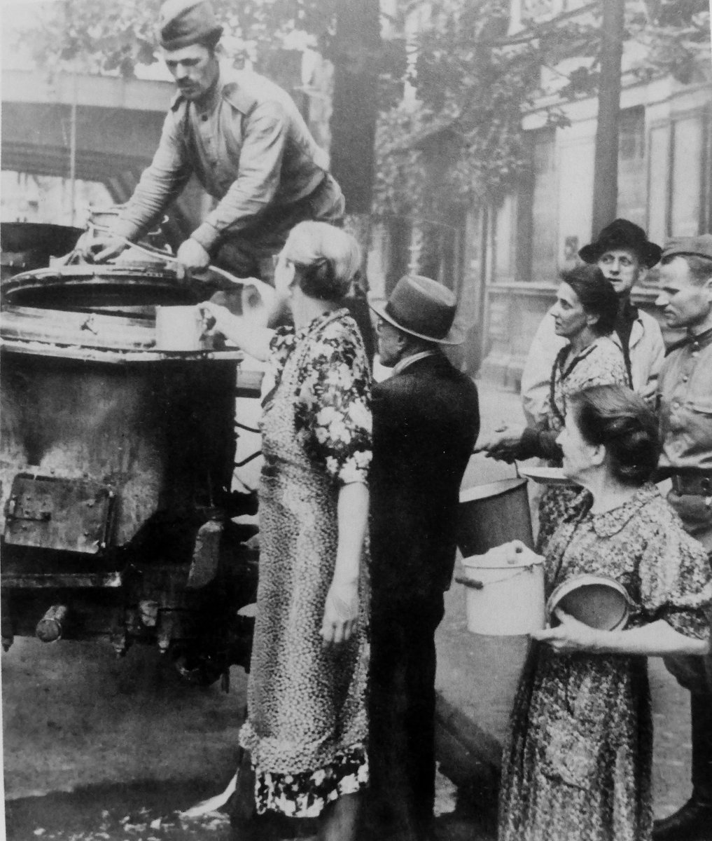 Red Army soldiers brutally assaulted women in Berlin by giving them a warm meal . May 1945.