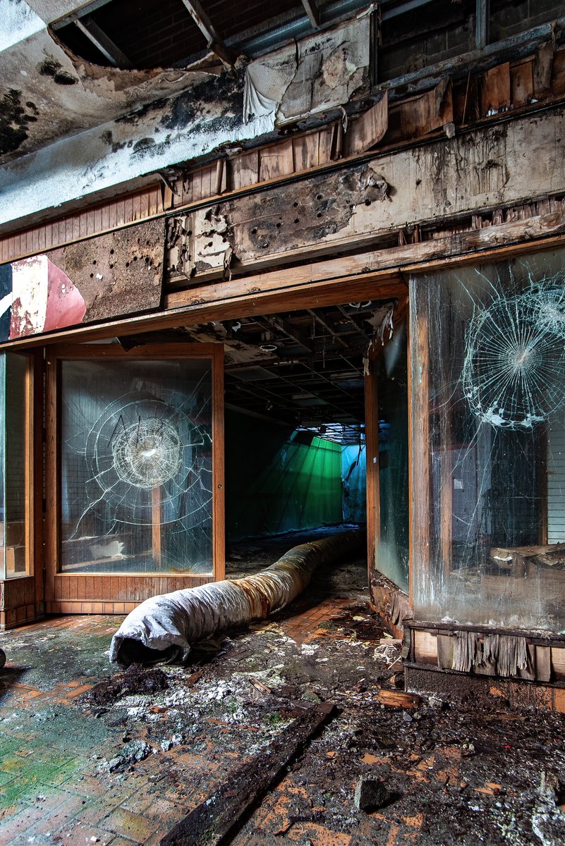 ExploresMr's tweet image. A rotting and decaying storefront in what used to be a bastion of American consumerism; inside the abandoned and since demolished Westland Mall in Columbus, Ohio (circa 2022).