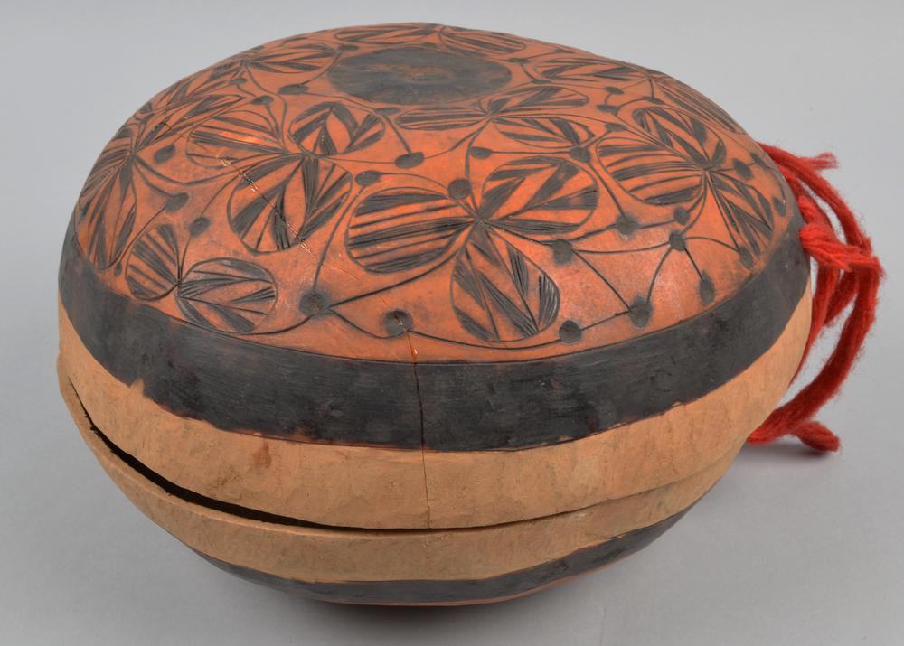 Bowl

Bowl with hinged cover amde from calabashes, the cover ornamented with a trefoil pattern cut and burnt in; the hinge made of scarlet worsted cloth.
Made by: Ibibio (1887) 
Modern day Cross River state 
Photo credit: British museum