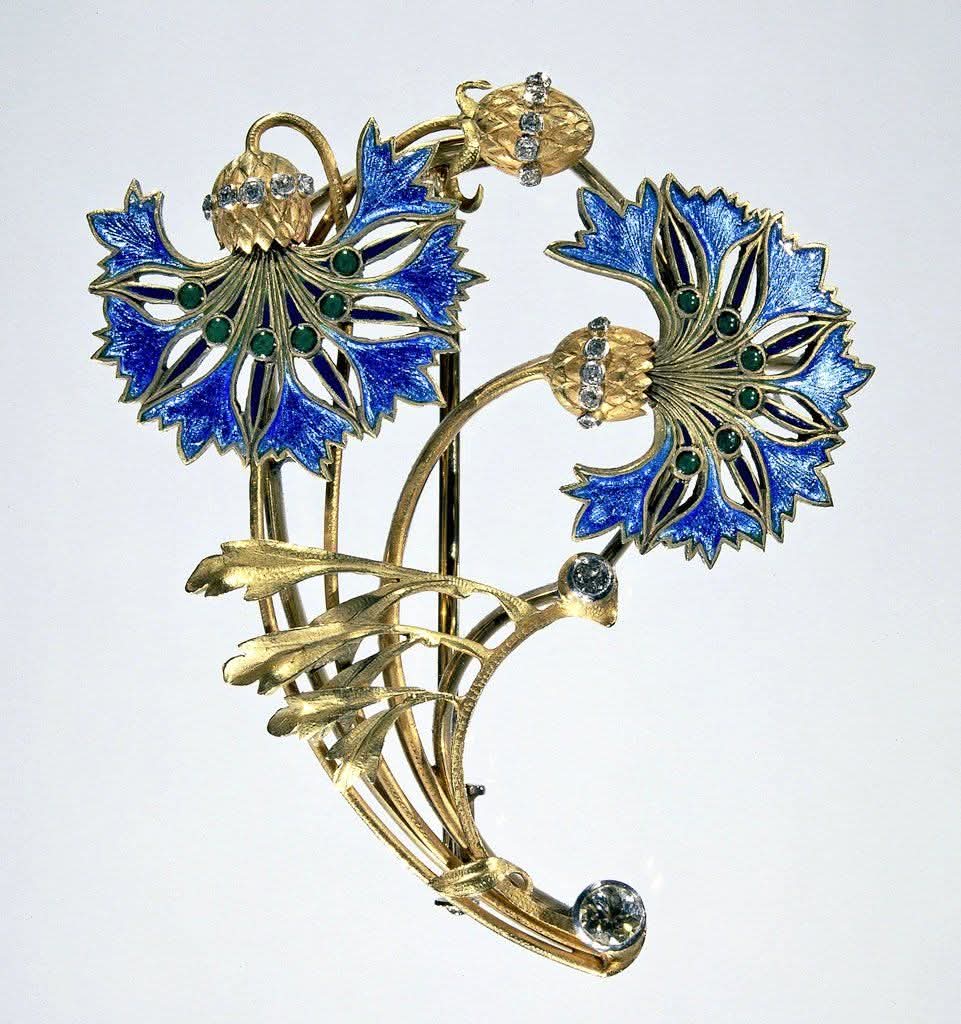 This Art Nouveau cornflower brooch is a gold, diamond, and enamel piece created around 1900-1910.