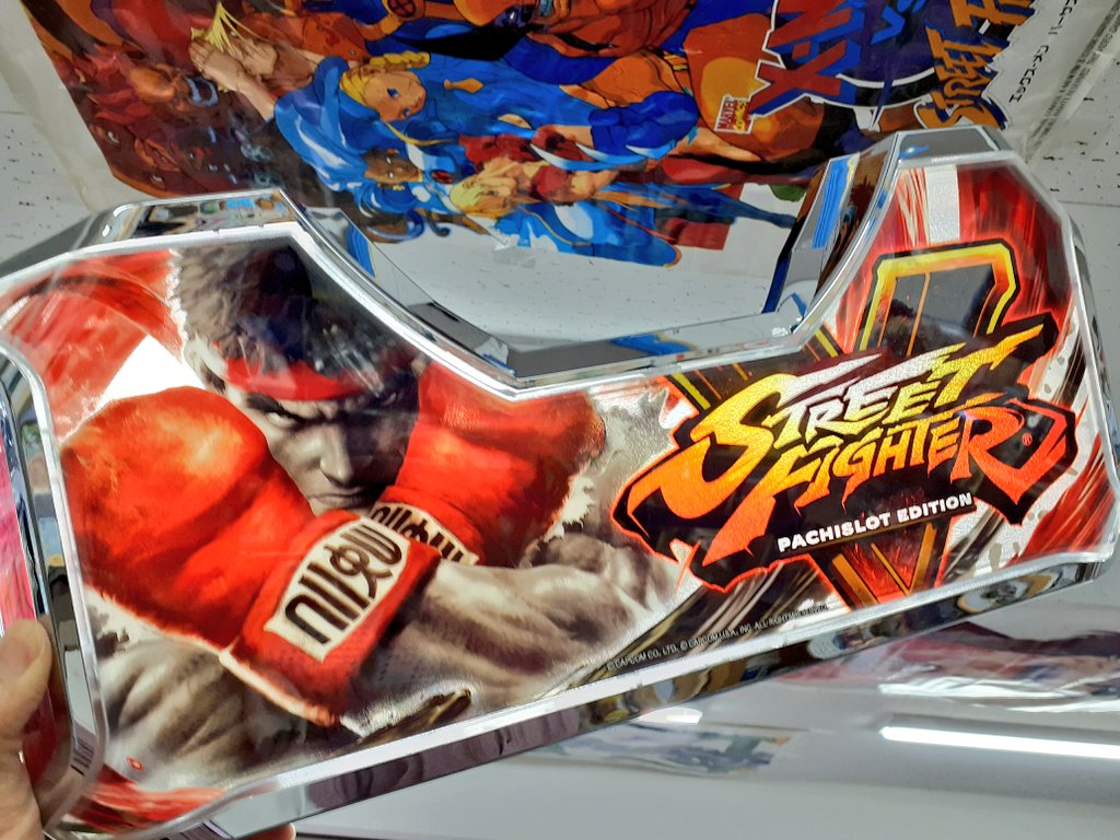 パネル「ストリートファイター V パチスロ エディション」品出中です。
先日、店内に「エックスメン VS. ストリートファイター」のポスターを展示いたしました。
こちらも是非見に来てください。
(パネルは裏から照明をあてています)
🎮️おくい