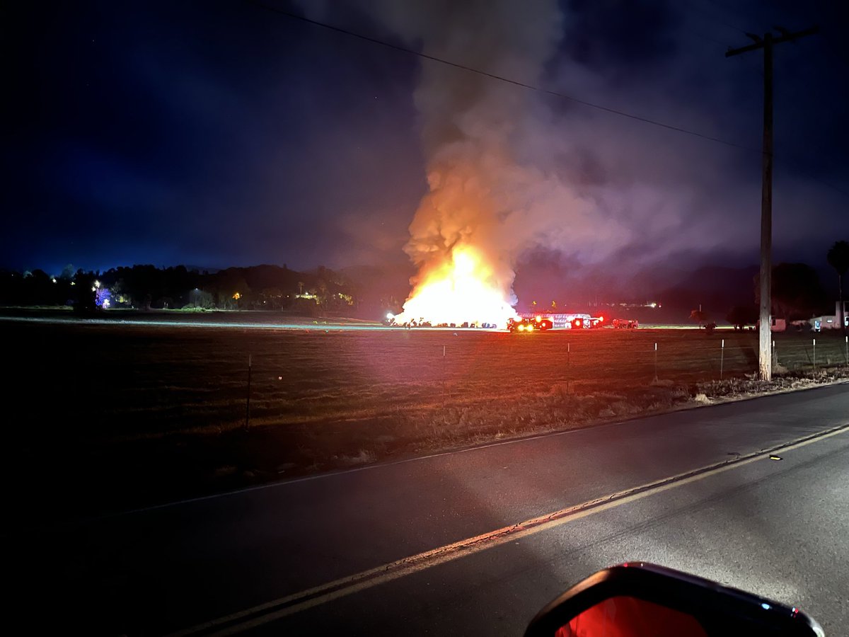 SDFD's tweet image. Multiple SDFD crews have been working to extinguish hundreds of large rolled and stacked hay bales on fire near 15750 Old Milky Way since 11:20 p.m. last night. @calfiresandiego is on scene supporting with dozers. Please note smoke may be visible in the area this morning.