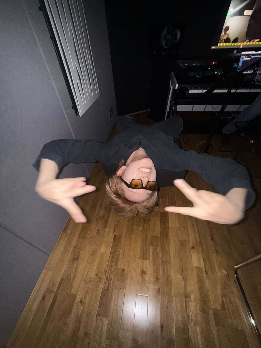 Strange angles, upside-down laughter, studio shadows turning playful chaos into art. He drifts across the floor like gravity decided to take a break, sunglasses catching the flash as he bends the room’s logic. Odd, bold, and oddly charming, exactly the kind of scene that lingers.