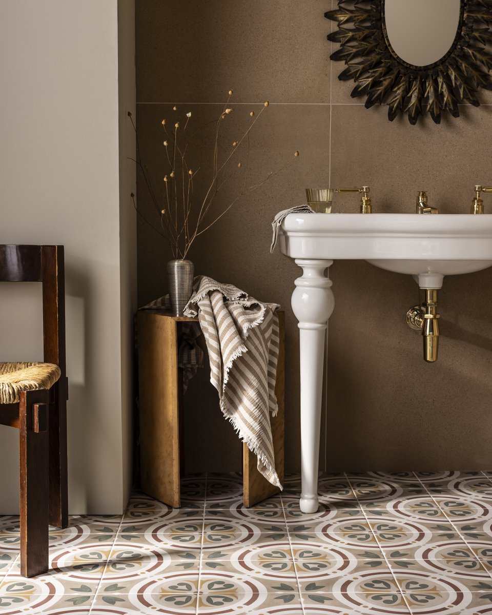 Warm, earthy tones and patterned tiles set a calm, grounded mood. At its centre, the china Windermere vanity brings sculptural lightness, its tapered legs and unlacquered brass adding a quiet glow. A balanced, crafted study in luxury bathroom design.