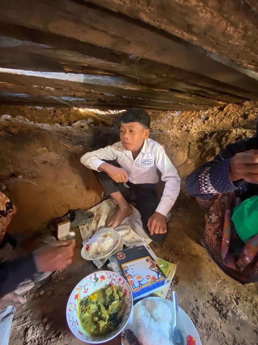 A Cambodian student and his family take shelter in a trench as Thai military gunfire attacks Cambodia.