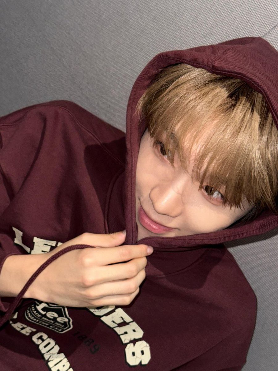 Hood pulled close, he hides a small grin as the studio lights brush across his face. Between takes for Hollywood Action, he folds himself into the beat, letting each breath find its place. In this quiet corner, focus sharpens, and every note edges closer to its final spark.