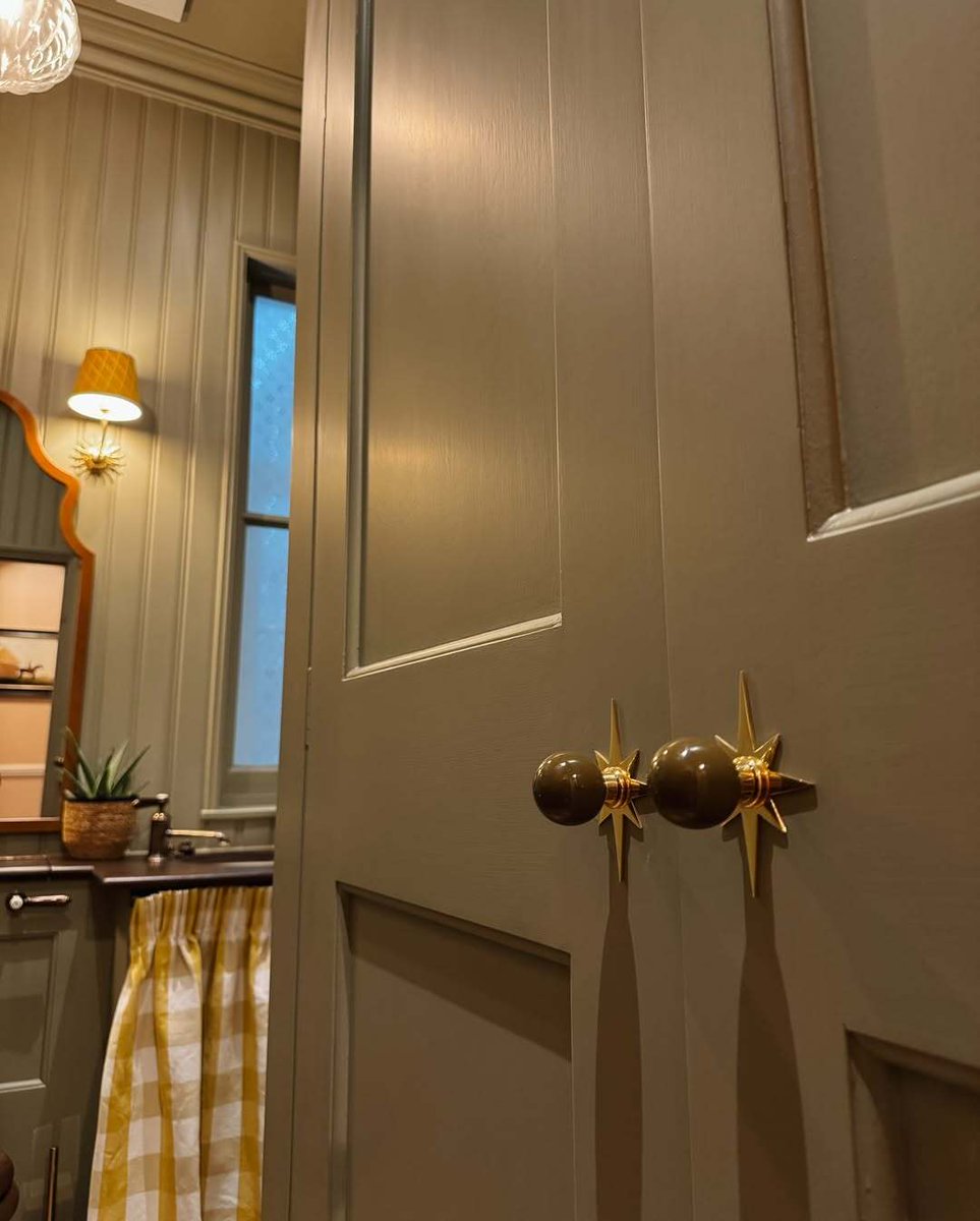 Binky Felstead’s downstairs loo pairs muted green panelling with dark wood, antique brass and a mustard gingham sink skirt for warmth and charm. Drummonds’ Coll Monobloc Tap adds a crafted, architectural note, grounding this playful, refined small-space bathroom.