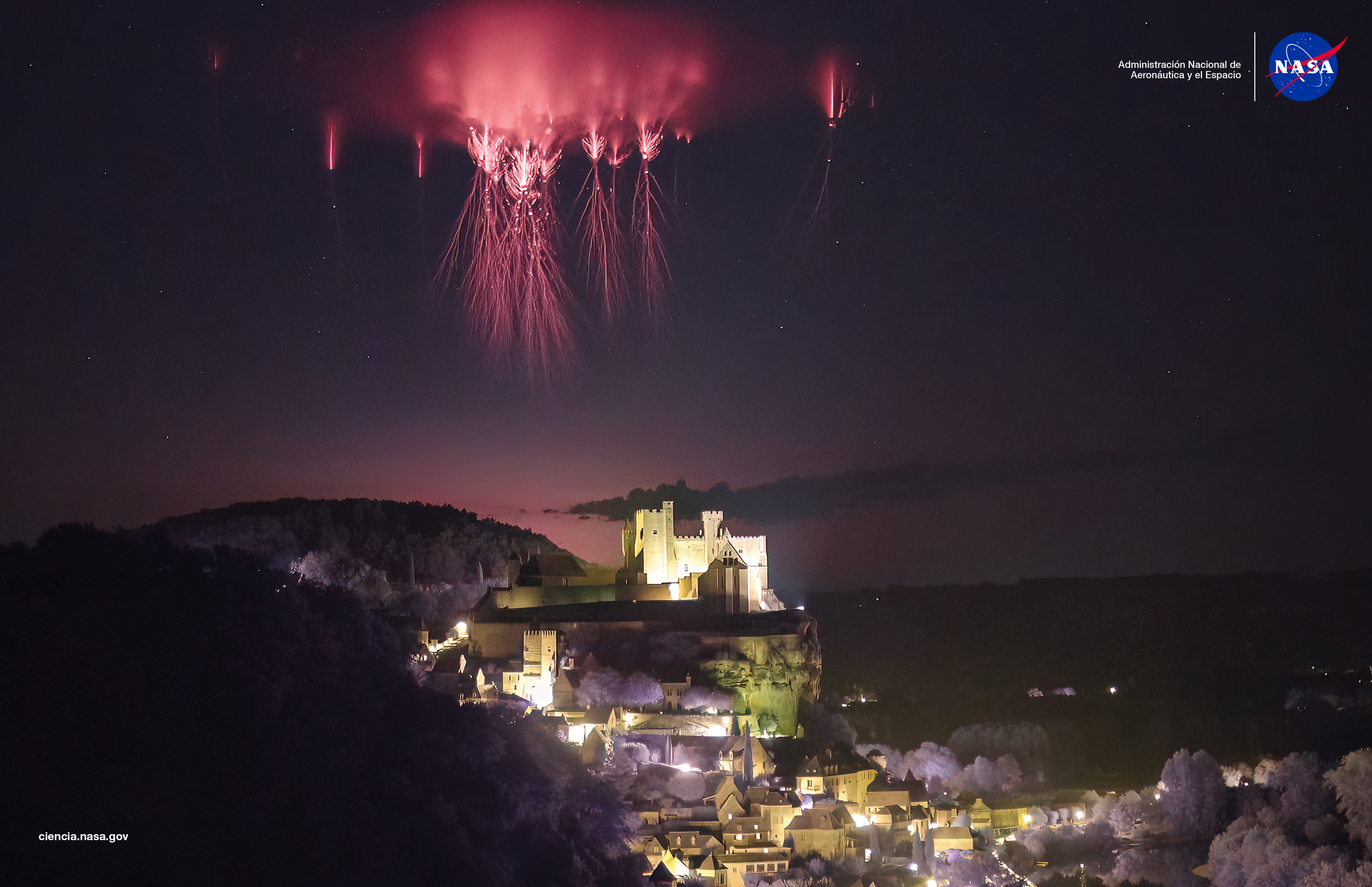 FotografÃ­a nocturna que muestra un duende o espectro rojo, un fenÃ³meno elÃ©ctrico atmosfÃ©rico superior poco comÃºn, que aparece como un destello carmesÃ­ sobre el castillo de Beynac, en DordoÃ±a, Francia. El duende se extiende verticalmente en el cielo oscuro sobre las nubes de tormenta, capturado por Nicolas Escurat, participante del proyecto de ciencia ciudadana Spritacular de la NASA.