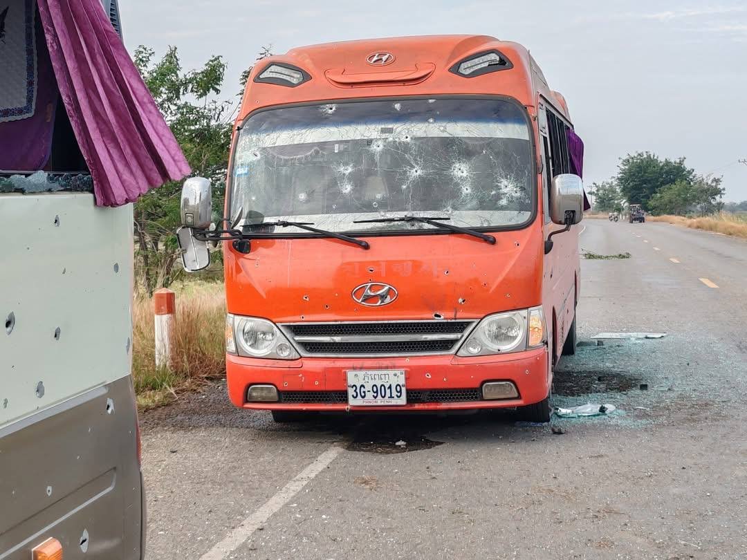 jacobincambodia's tweet photo. How are Thai soldiers this far inland? Much of the damage on this bus looks like small arms or machine gun fire. The tight grouping on the windshield and the clean bullet holes along the side don’t match artillery fragmentation. If this happened on National Road 56, it raises some serious questions.